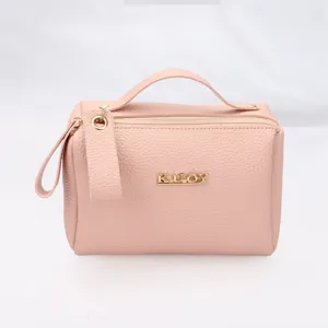 Portable pink pebbled leather cosmetic wash bag with gold KUOY logo and top handle
