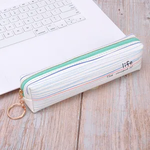 Minimalist striped PU pencil pouch with green zipper and gold keyring on a white laptop