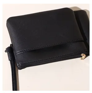Detail macro view of a black PU leather pouch showing Saffiano texture and gold zipper