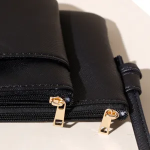 Detailed close-up of a black PU leather crossbody bag featuring stylish golden dual zippers