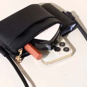Minimalist black PU leather crossbody square bag showing capacity with phone and makeup