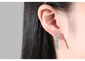 Close-up of elegant floral drop earrings with sparkling cubic zirconia worn on an ear
