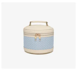 Elegante runde gewebte Kosmetiktasche in Hellblau und Beige mit Griff und Gold-Zips.