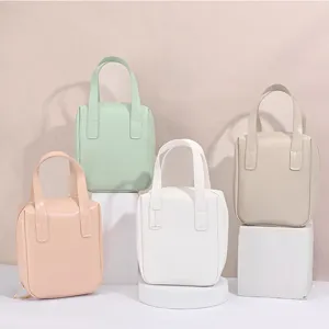Set mit vier bunten Make-up-Taschen aus PU-Leder in Pastelltönen auf weißen Blöcken