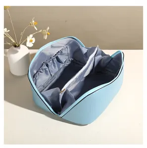 Detalle de neceser de PU con compartimentos interiores y bolsillo con cremallera.