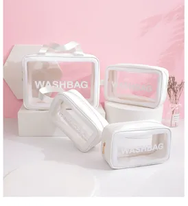 Professional set of four waterproof transparent travel cosmetic bags with white trim handles.