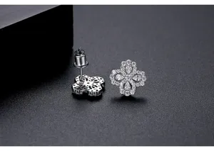 Close-up of silver-tone four-petal flower earrings with sparkling cubic zirconia.