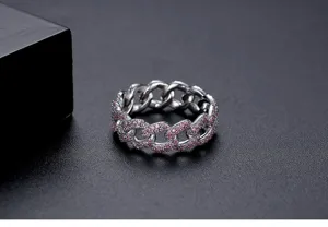 Detalle de anillo de cadena cubana plateado con brillantes piedras de color rosa