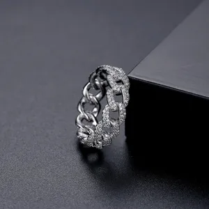Anillo de cadena cubana plateada con pavé de piedras brillantes sobre superficie negra
