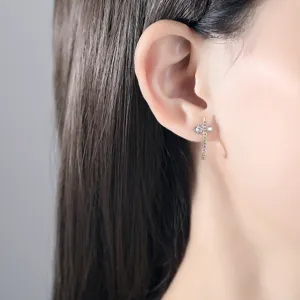 Elegant gold cross stud earring with sparkling cubic zirconia shown on an Asian model ear