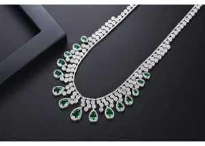 Detalle de collar lujoso en tono plateado con gotas de circonita verde en forma de pera