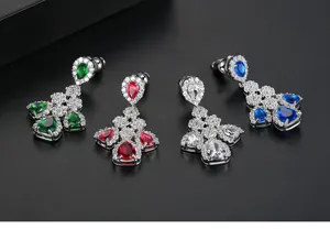 Vista detallada de pendientes largos vintage con circonitas de colores en forma de lágrima.