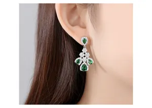 Primer plano de elegantes pendientes vintage con piedras verdes y detalles de circonita