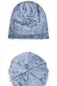 Macro detail of a light blue distressed slouchy beanie with stylish ripped hole textures