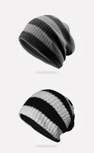 Macro detail view of two stylish striped knit beanies in grey/black and white/black patterns