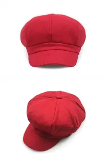 Detailed front and top views of a vintage red wool newsboy cap on white background