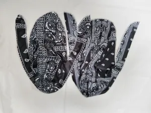 Dettaglio di un durag con stampa paisley bianca e nera, lacci lunghi e tessuto elastico