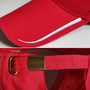 Detail of a red baseball cap featuring an extra long brim and adjustable metal buckle