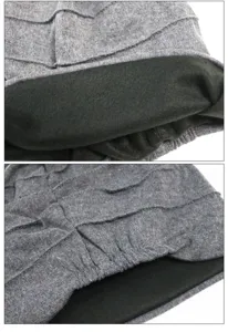 Primer plano del tejido gris plisado y el forro polar negro cálido de este gorro.