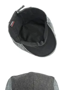 Detailed macro view showing the grey herringbone pattern and black inner lining of the flat cap