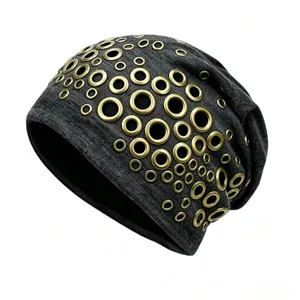 Close-up detail of punk style knitted slouchy beanie with gold metal eyelet decorations