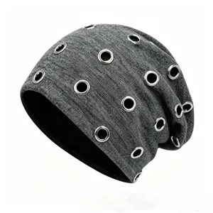 Close-up detail of a grey knitted slouchy beanie with silver metal eyelet rings