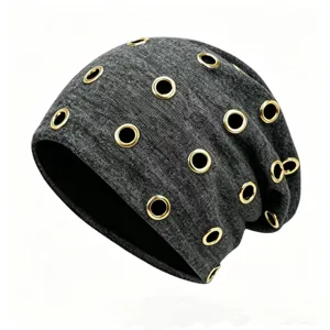 Macro detail of a grey punk style beanie featuring multiple gold metal eyelet decorations