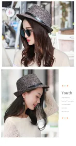 Detailed view of a brown tweed fedora hat with a black leather band on a model.