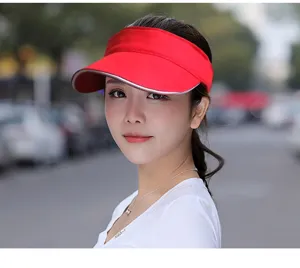 Close-up view of a model wearing a vibrant red sun visor hat for summer outdoor sports