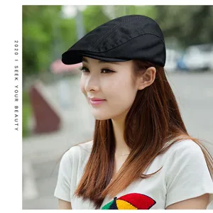 Close-up of a black cotton flat cap worn by a model in a stylish outdoor setting