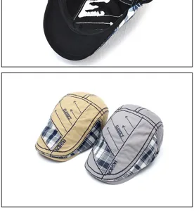 Detail of vintage-style plaid beret caps in beige and grey with printed patterns