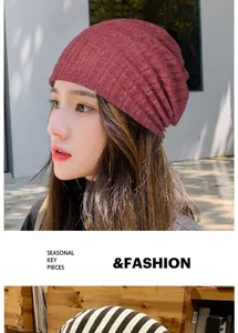 Primo piano di un berretto slouchy leggero in maglia rossa indossato da una modella asiatica.