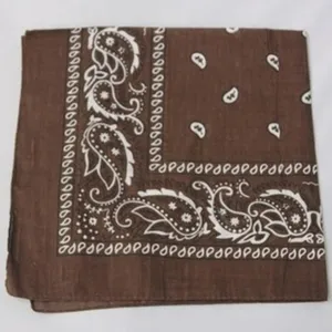 Vista detallada de una bandana de algodón marrón con motivos paisley blancos y borde decorativo