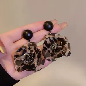 Detailed close-up of vintage leopard print flower earrings featuring a black stud