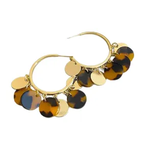 Detailed close-up of vintage gold hoop earrings featuring leopard print and metal charms