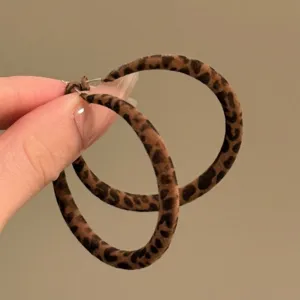 Macro view of large leopard print hoop earrings with retro brown velvet texture
