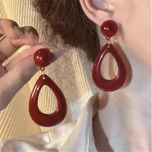 Close-up of elegant French vintage dark red teardrop earrings shown on a model's ear