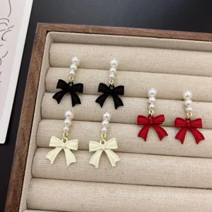 Imagen detallada de tres pares de elegantes pendientes de perlas con lazo de estilo francés