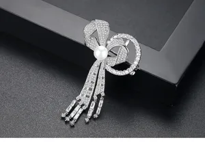 Gros plan sur une élégante broche nœud avec zircons micro-sertis et perle blanche