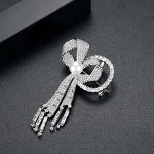 Broche nœud élégante en argent avec zircons cubiques et détail de perle blanche centrale