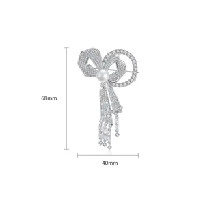 Broche nœud élégante avec micro-pavé de zircone et perle, taille 68mm sur 40mm.