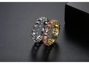 Primer plano de anillos de eternidad bañados en oro y plata con circonitas rosas y claras.