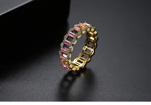 Primer plano de un anillo de latón dorado con circonitas rosas y pavé de cristales.