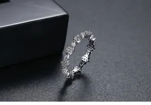 Primer plano detallado de un elegante anillo de flores de plata con circonitas brillantes