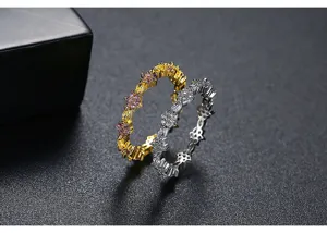 Detalle de elegantes anillos de flores en oro y plata con circonitas brillantes
