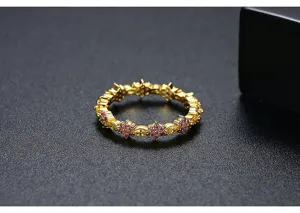 Vista macro detallada de un anillo de flores chapado en oro con circonitas rosas