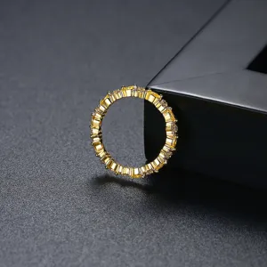 Elegante anillo de flores chapado en oro con circonitas amarillas en fondo oscuro