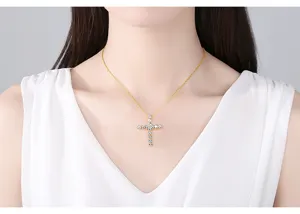 Detail shot of a sparkling zircon cross pendant necklace worn by an elegant model