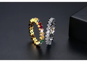 Primer plano macro de anillos geométricos con circonitas baguette de colores vivo