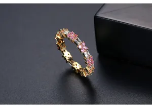Elegante goudkleurige ring met roze bloemenzirkonia en heldere baguettegeslepen steen.